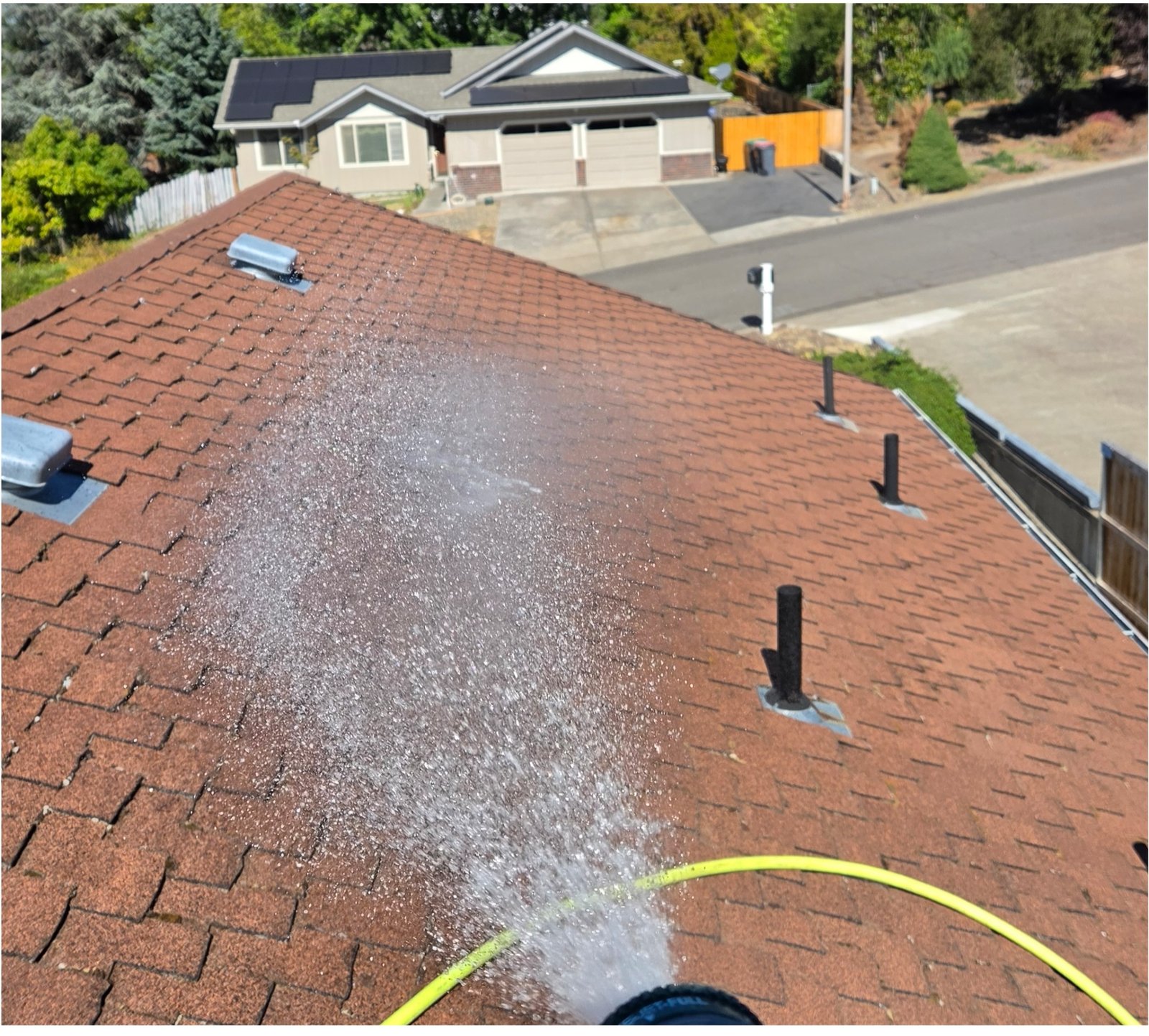Moss being rinsed from a shingle roof in Medford, Oregon